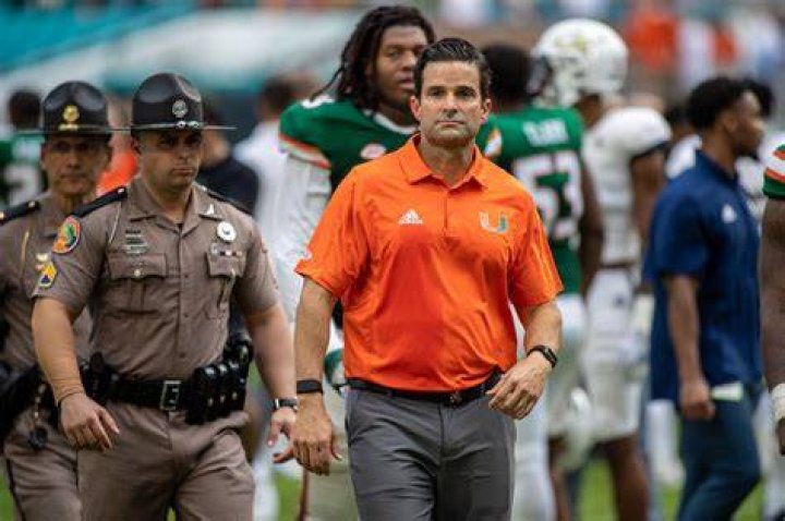 Miami head coach Manny Diaz, right, talks to his wife, Stephanie Diaz